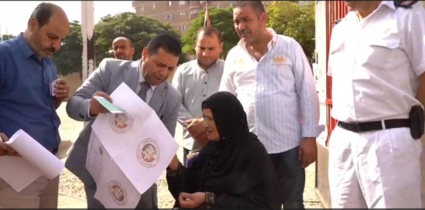 قاضي بدرجه انسان يستقبل مريضة مسنه خرج لها  بالخارج اللجنه لتسهيل ادلاء صوتها بالانتخابات مجلس الشيوخ